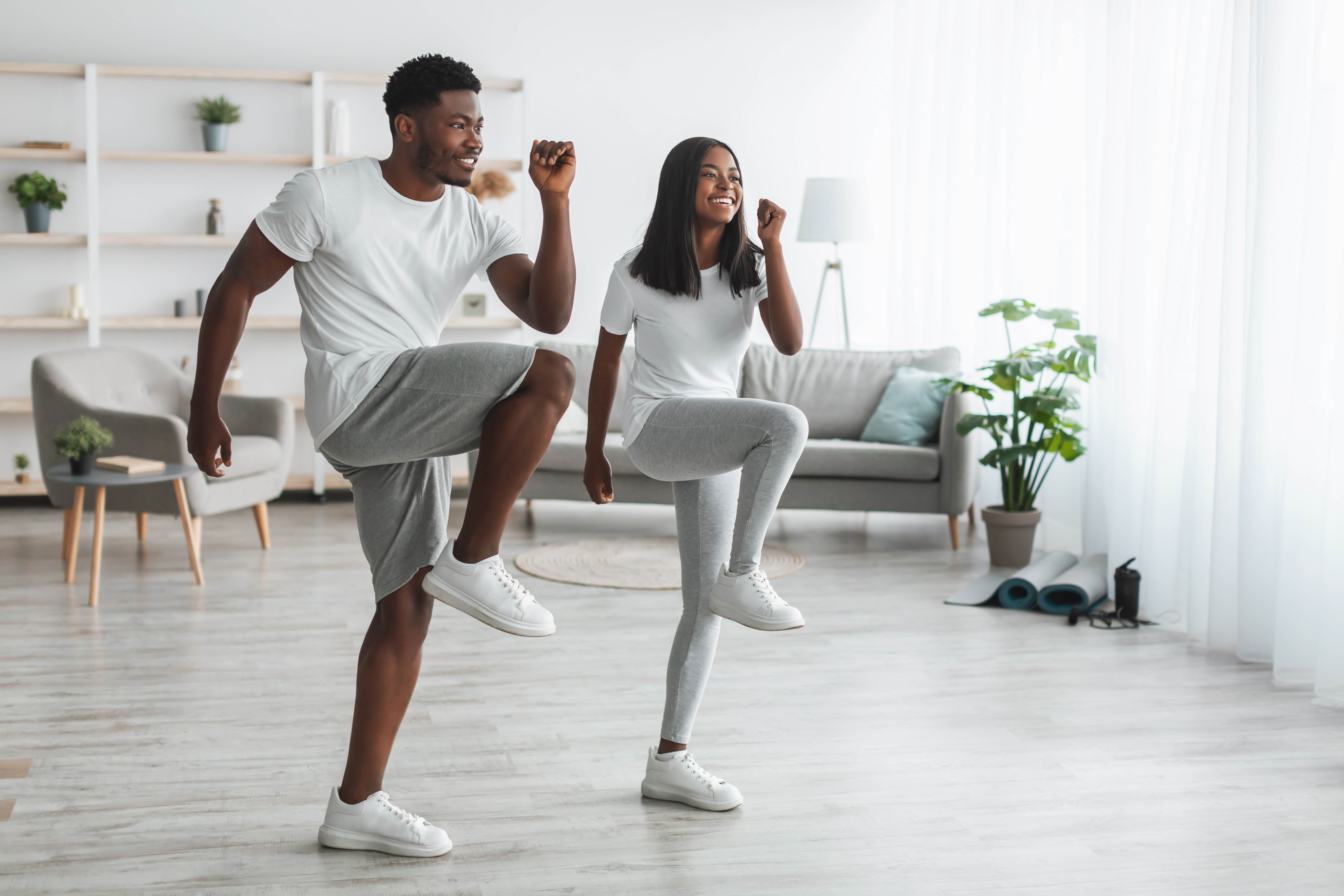 Young African American couple completes an at-home workout in their living room Young African American couple completes an at-home workout in their living room